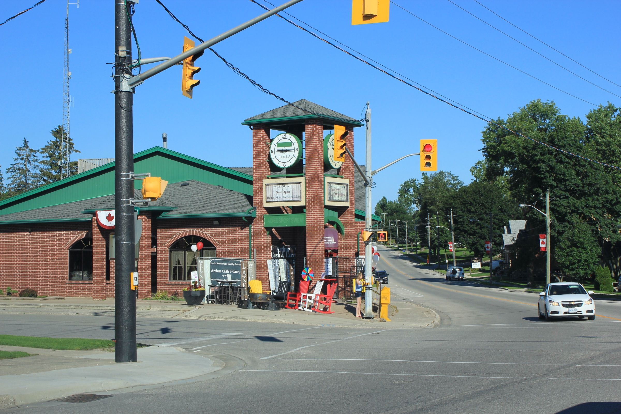 The main corner of Arthur, with the clock tower on Smith Street and maple-leaf flags along the highway through the village
